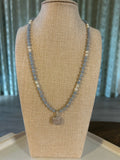 Necklace on a beige jewelry display with a blurred background