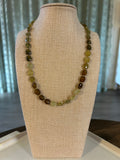 Beaded necklace on a mannequin bust with a neutral background