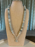 Necklace with blue rondelle beads on a beige display stand