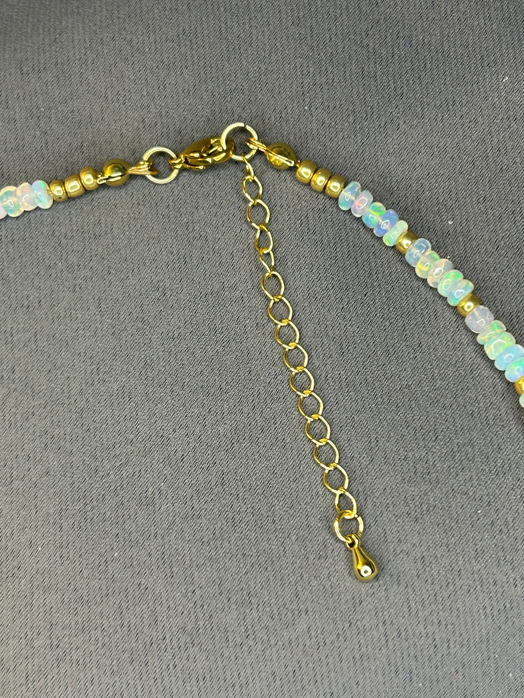 Necklace with gold chain and small beads on a gray background