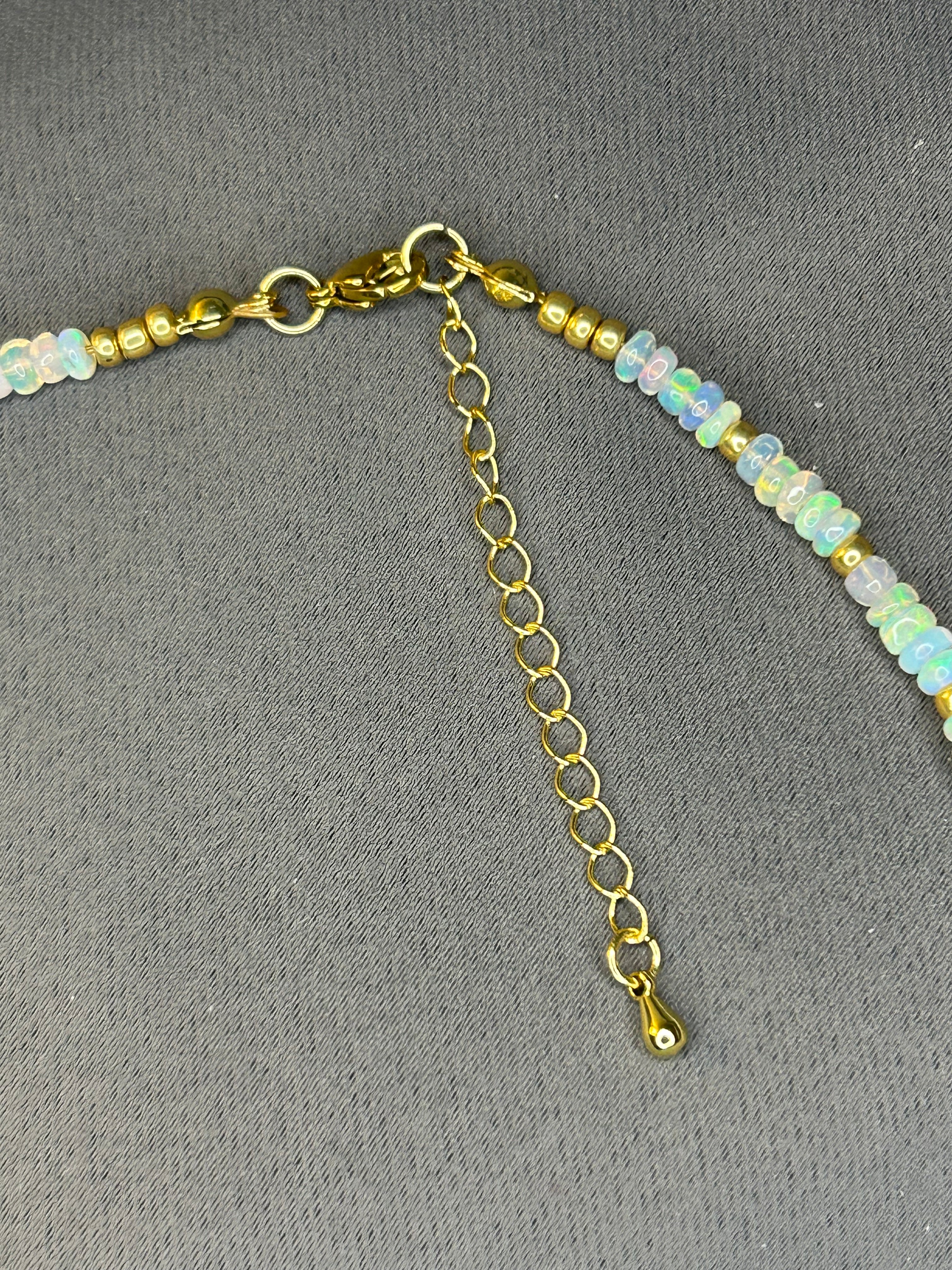 Necklace with gold chain and small beads on a gray background