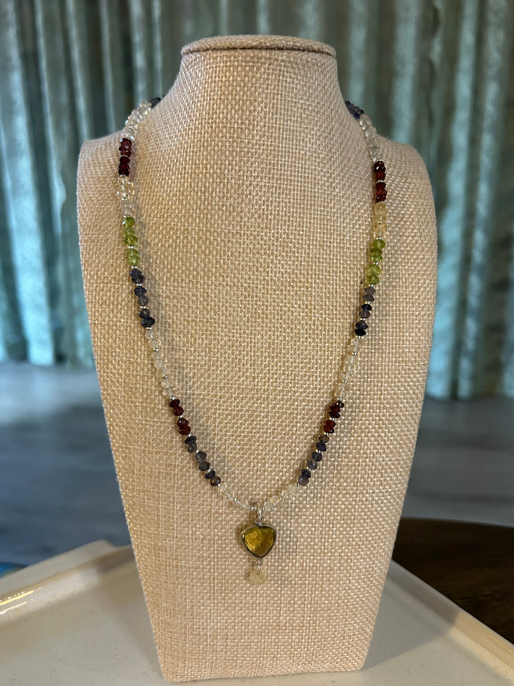Beaded necklace on a mannequin bust with a neutral background