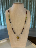 Beaded necklace on a mannequin bust with a neutral background